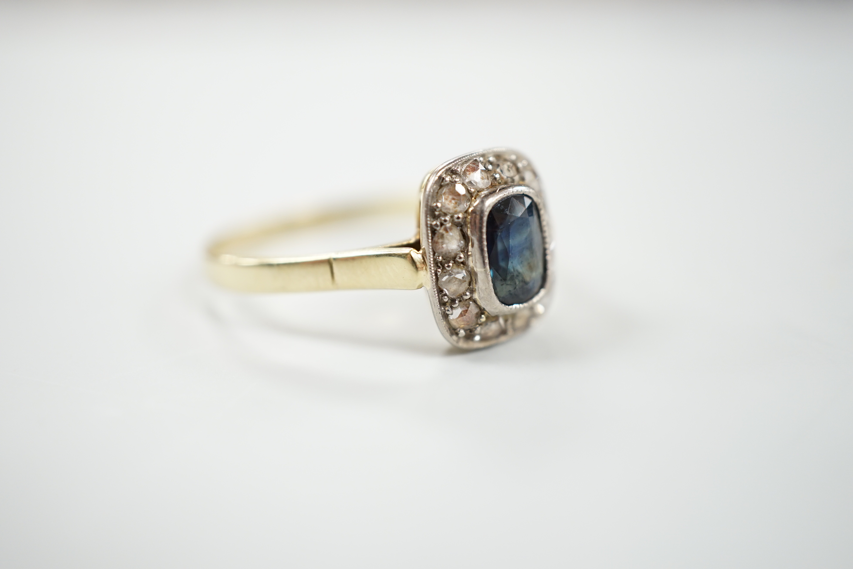 A mid 20th century yellow metal, sapphire and diamond set rectangular cluster ring, size W/X, gross weight 3.7 grams.